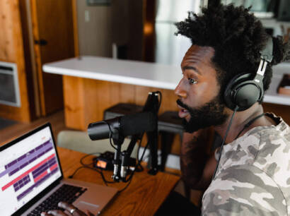 A man with headphones on looking at his laptop.